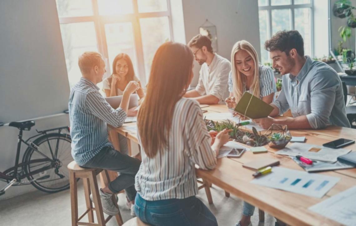 Ambiente creativo de escritura satírica con personas trabajando en sus textos